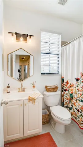 Bathroom featuring vanity, a shower with curtain, and light tile patterned floors