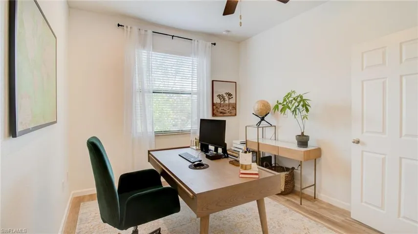 Office with light wood-type flooring and ceiling fan