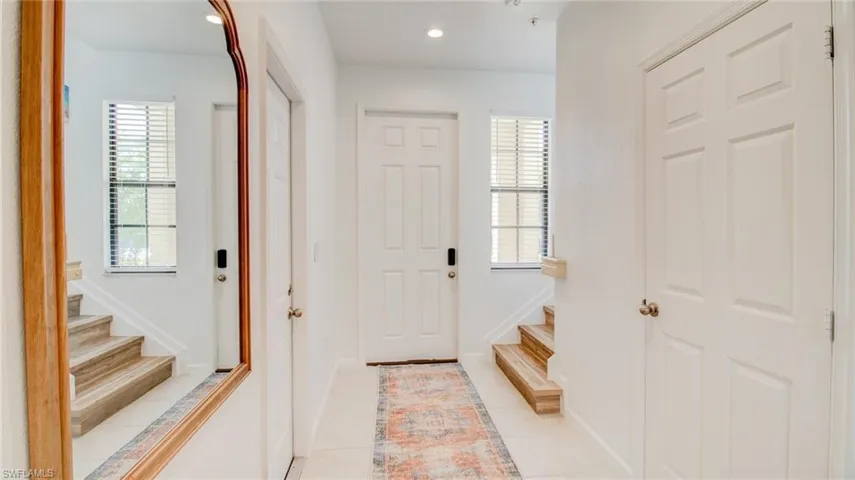 Foyer with light tile patterned floors and recessed lighting