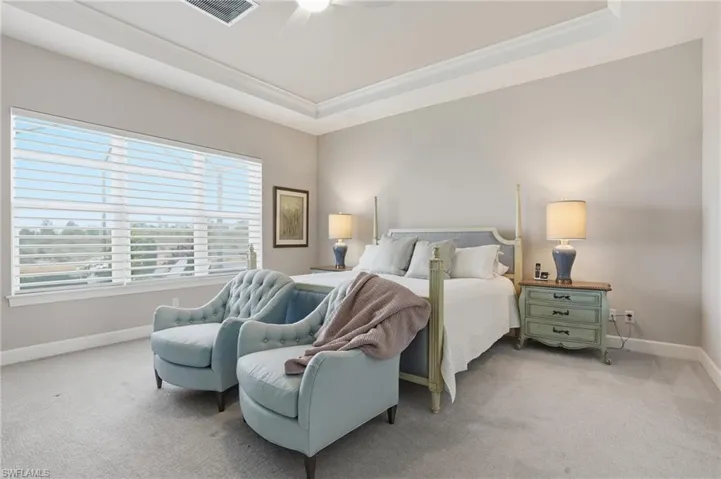 Bedroom featuring carpet, a raised ceiling, ceiling fan, and crown molding