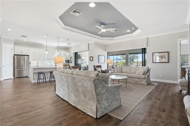 Living room featuring crown molding, healthy amount of natural light, dark wood-style floors, a ceiling fan, and recessed lighting