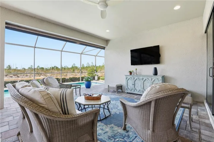 View of patio / terrace featuring a sunroom, an outdoor pool, an outdoor living space, and glass enclosure