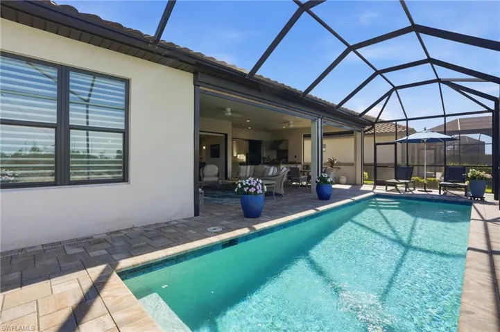 Swimming pool featuring a lanai, a sunroom, and a patio