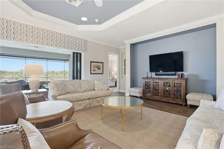 Living room featuring wood finished floors and crown molding