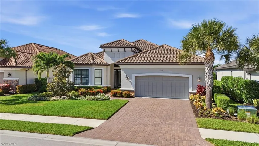 Mediterranean / spanish-style house featuring stucco siding, decorative driveway, and a front lawn