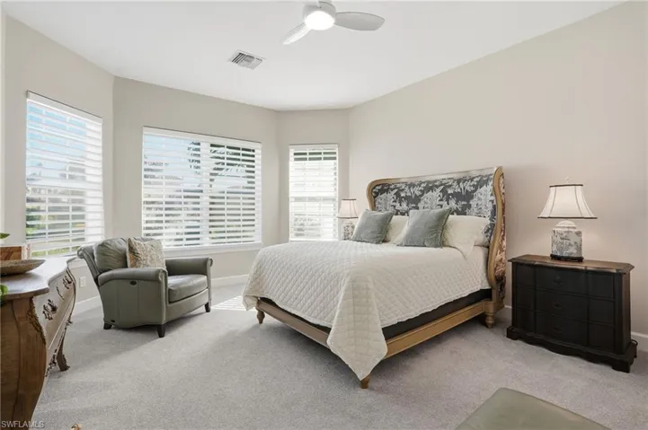 Carpeted bedroom with ceiling fan and baseboards