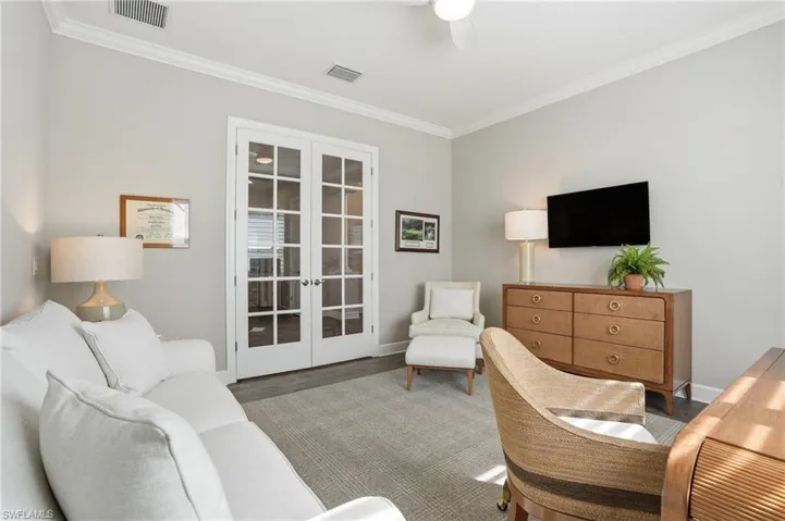 Living area featuring french doors, ornamental molding, wood finished floors, and a ceiling fan