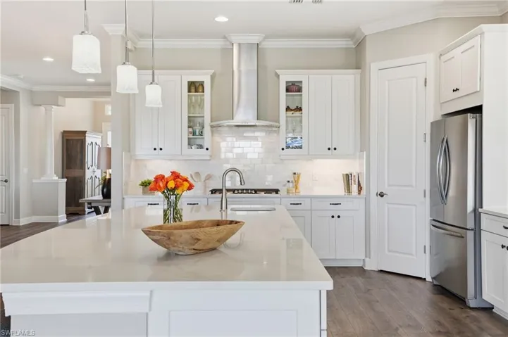Kitchen featuring crown molding, dark wood-style floors, glass insert cabinets, white cabinets, and freestanding refrigerator