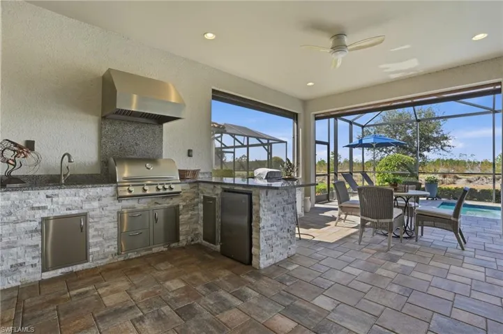 View of patio / terrace featuring glass enclosure, a ceiling fan, a sunroom, area for grilling, and an outdoor pool