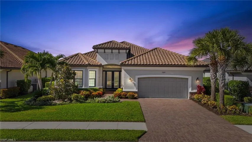 Mediterranean / spanish-style house featuring decorative driveway, french doors, an attached garage, a tile roof, and stucco siding