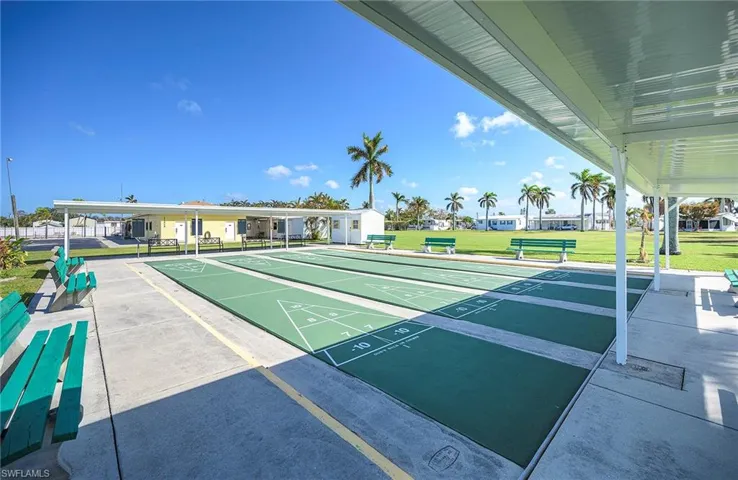 View of property's community featuring a yard and shuffleboard