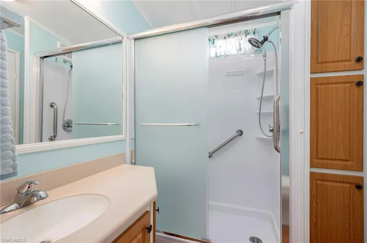 Full bath with vanity and a shower stall