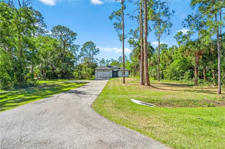 View of front of home with driveway and a front lawn