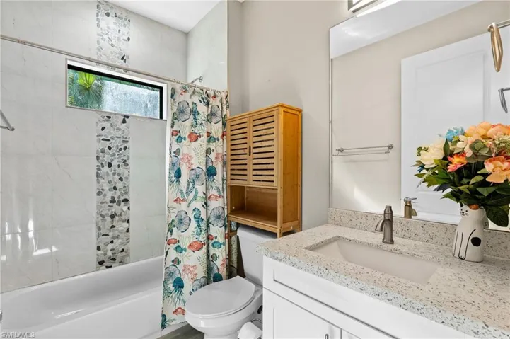 Bathroom featuring vanity, toilet, and shower / tub combo
