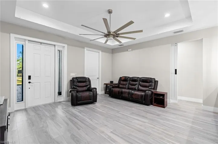 Living area featuring recessed lighting, baseboards, a raised ceiling, ceiling fan, and visible vents