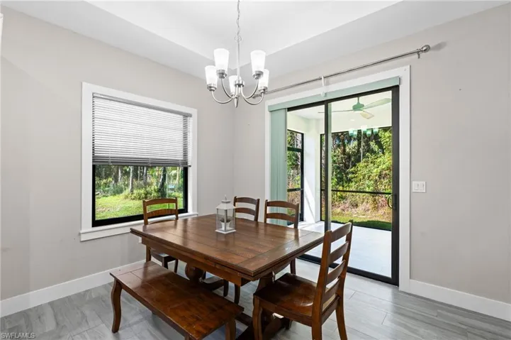 Dining room featuring baseboards, a chandelier, and a wealth of natural light