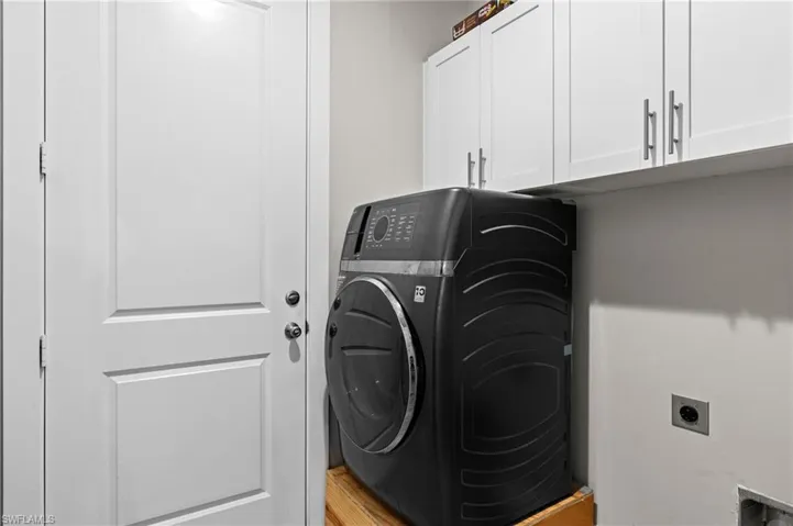 Washroom featuring cabinet space and washer / dryer