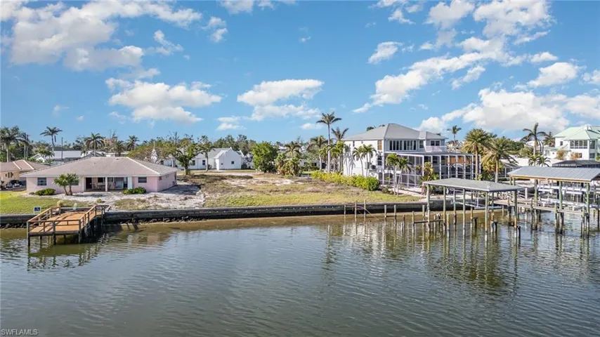 Dock area featuring a residential view, boat house, and water view