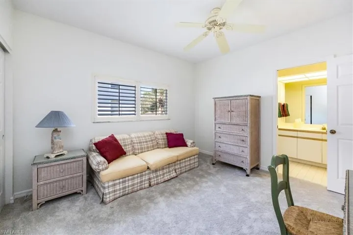 Living area with ceiling fan and light carpet