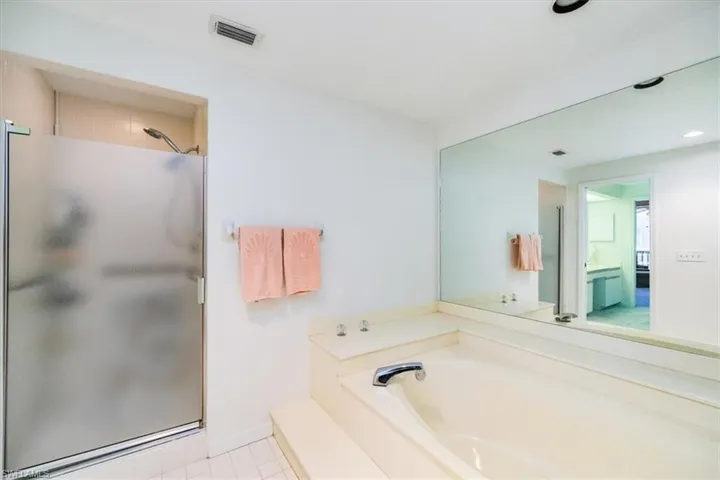 Bathroom featuring plus walk in shower and tile patterned floors