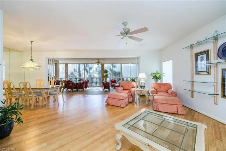 Living room featuring hardwood / wood-style floors, ceiling fan, and a healthy amount of sunlight