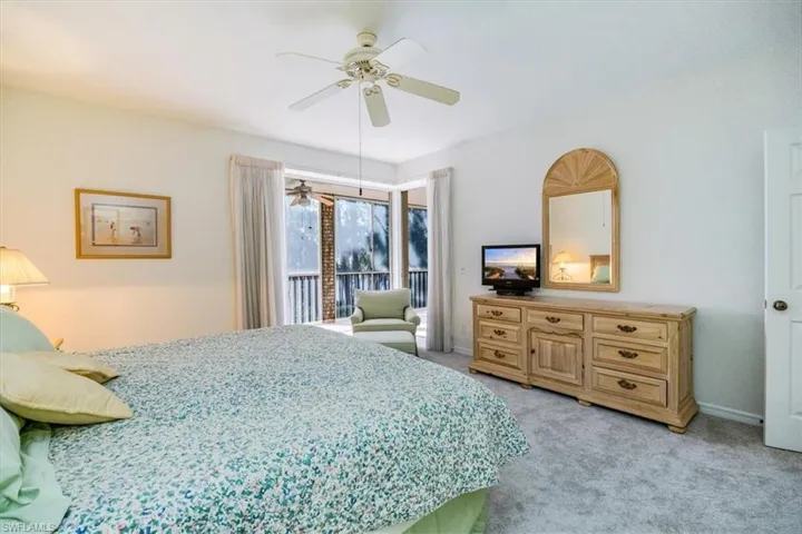 Carpeted bedroom featuring access to outside and ceiling fan