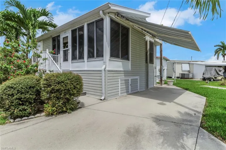 View of home's exterior with a sunroom and concrete driveway