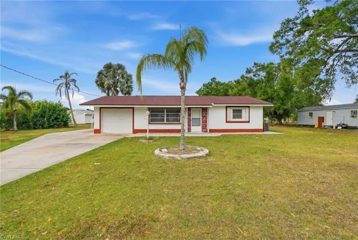 Ranch-style home with an attached garage, concrete driveway, a front yard, and stucco siding