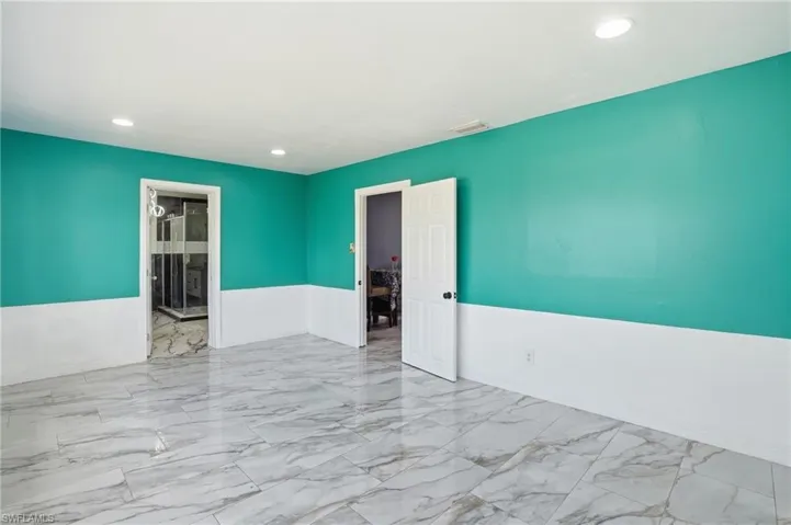 Spare room featuring light marble finish flooring, recessed lighting, and a wainscoted wall