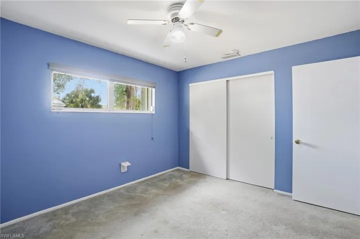 Unfurnished bedroom with a closet, light carpet, and a ceiling fan