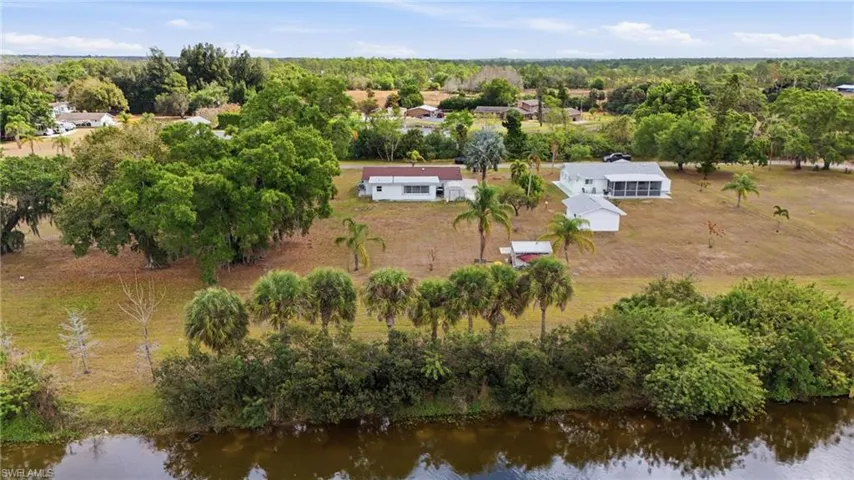Aerial view of a nearby body of water and a tree filled landscape