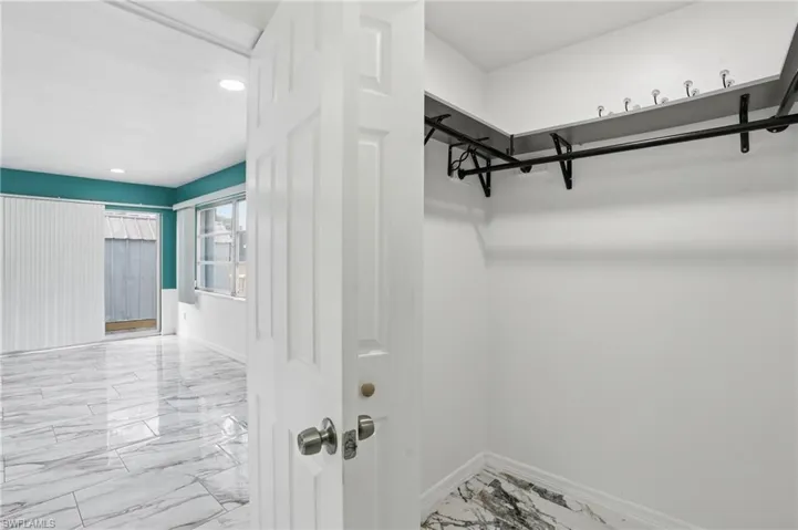 Walk in closet featuring light marble finish floors