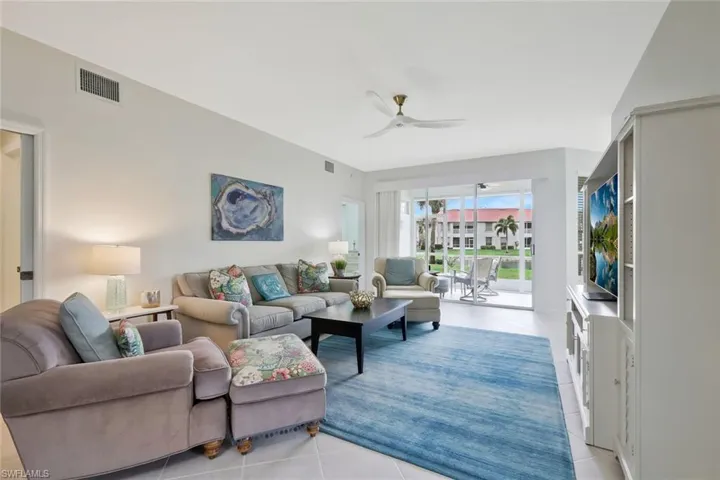 Living area featuring ceiling fan and light tile patterned flooring