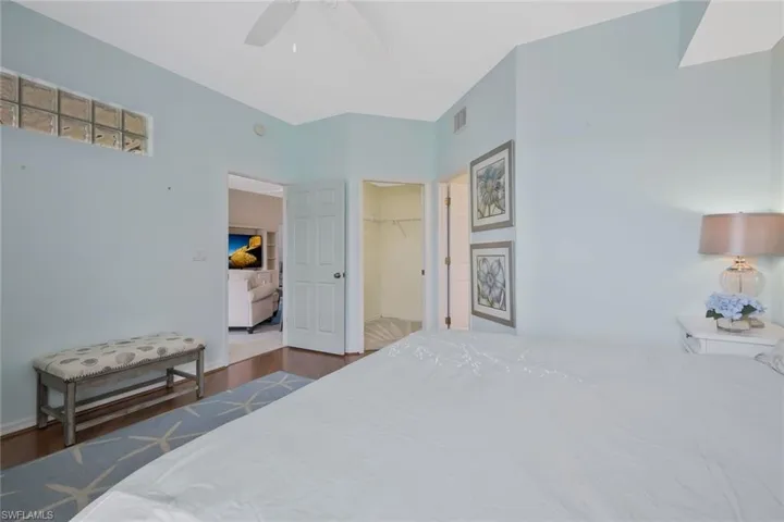 Bedroom with a spacious closet, wood finished floors, and ceiling fan
