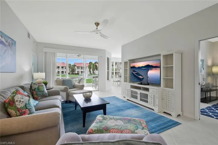 Living area with ceiling fan and tile patterned flooring