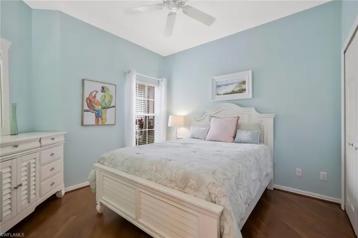 Bedroom featuring dark wood finished floors, a ceiling fan, and a closet