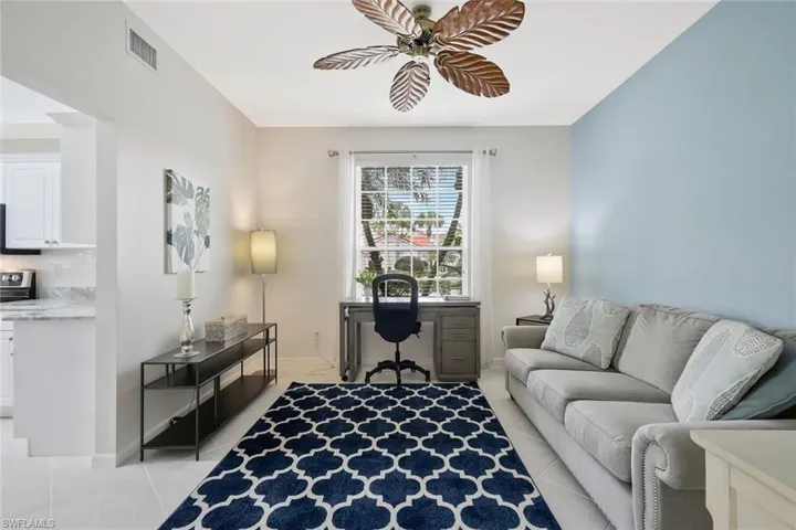 Home office with a ceiling fan and light tile patterned floors