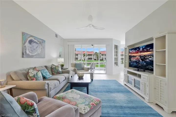 Living area featuring ceiling fan and light tile patterned flooring