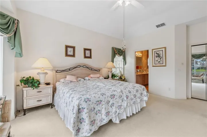 Carpeted bedroom with ceiling fan, connected bathroom, and access to outside