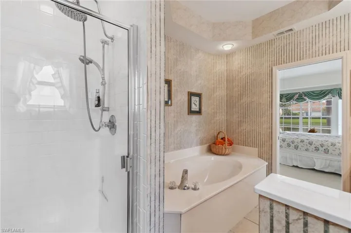 Bathroom featuring tile patterned flooring and shower with separate bathtub