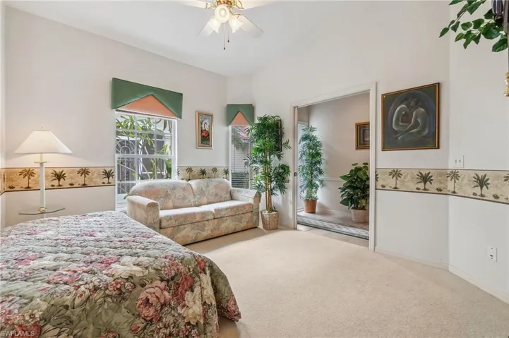 Carpeted bedroom/office with ceiling fan
