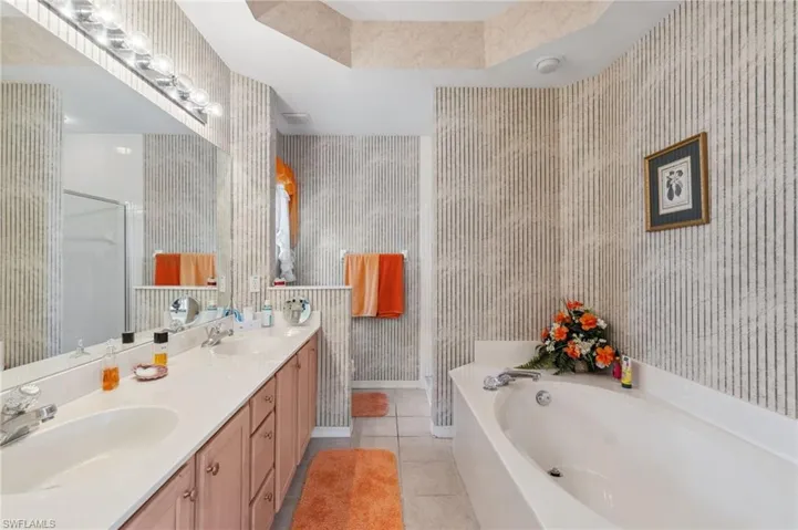Bathroom with tile patterned flooring, vanity, and shower with separate bathtub