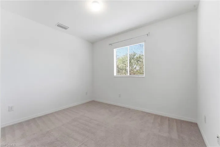 Empty room with light carpet and baseboards
