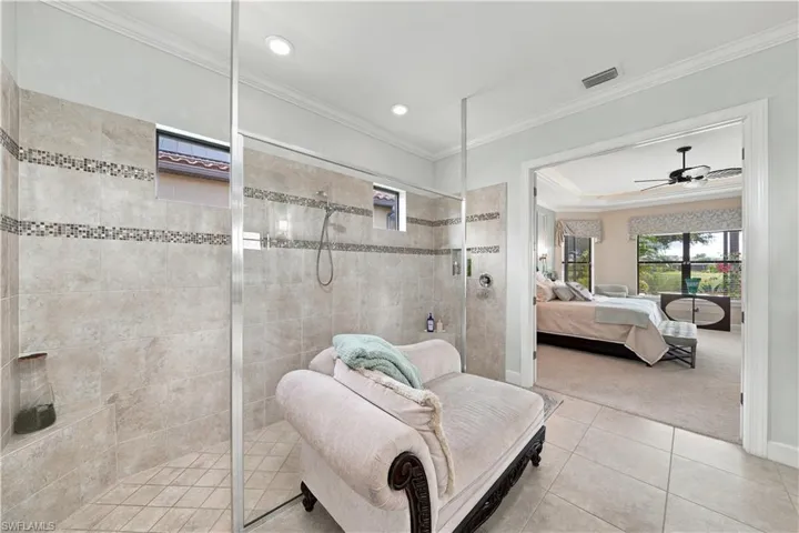 Walk-in shower with full-height tile surround, mosaic accent bands, and glass enclosure