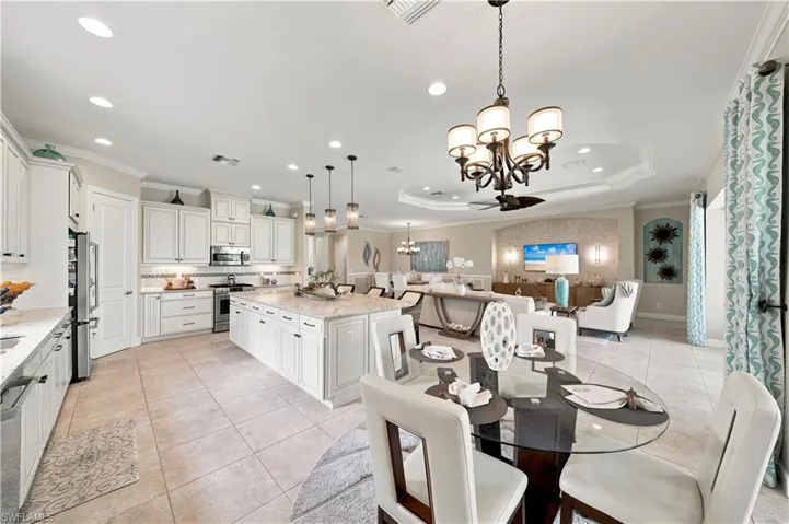 Spacious open-concept living area featuring a gourmet kitchen with white shaker cabinetry, granite countertops, and stainless steel appliances