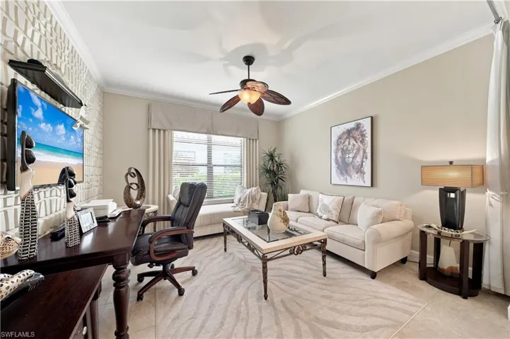 Spacious interior featuring a decorative accent wall, crown molding, and a ceiling fan with light fixture