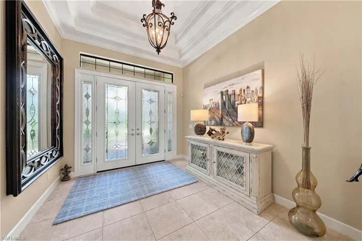 Inviting entryway featuring double front doors with decorative frosted glass panels and a transom window above