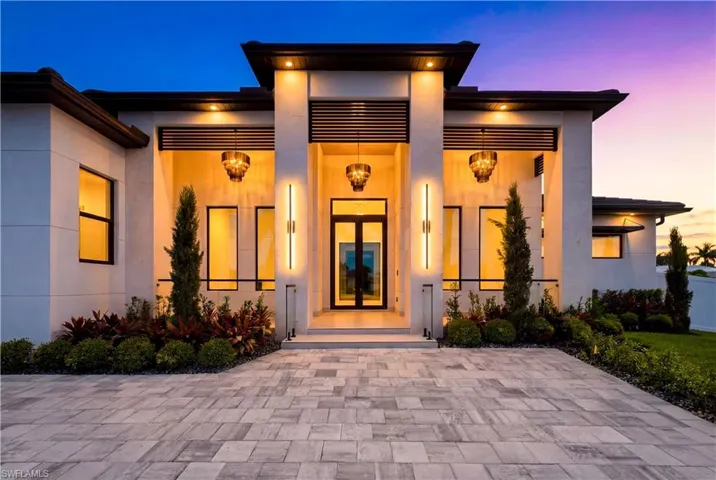 Front porch w/ marble columns, impact glass accents, wood ceiling & striking chandeliers