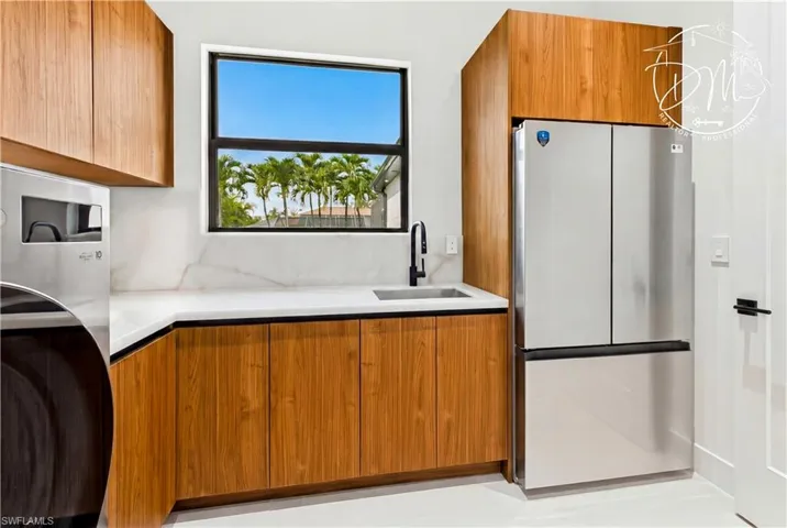 Laundry w/ utility sink, backsplash, extra refrigerator/freezer, folding counter & storage