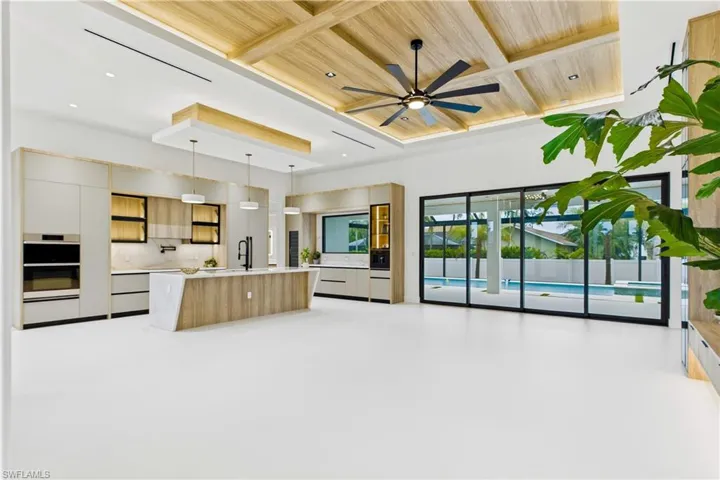 Living room w/ 16-ft COVE CEILING & flat wood panels & beams